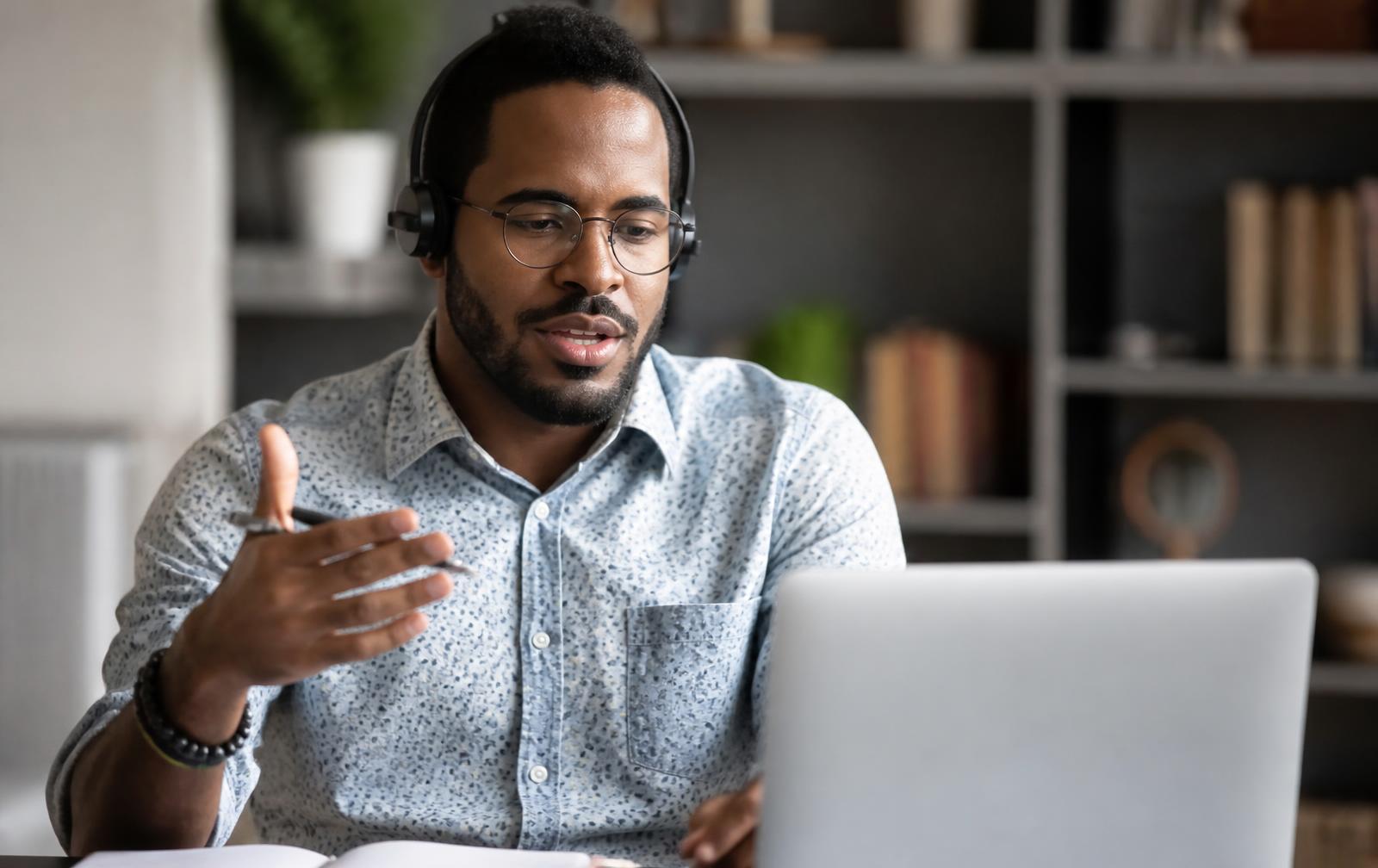 Candidate wearing headphones answering questions in a recorded online interview on a laptop