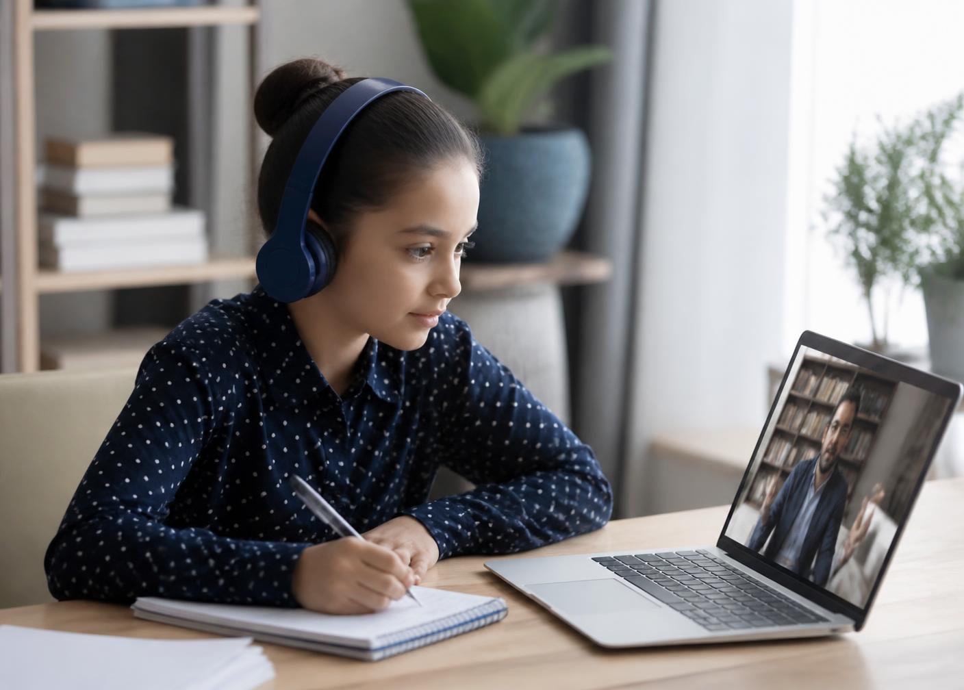 Student wearing headphones attending an interactive AI live class on a laptop